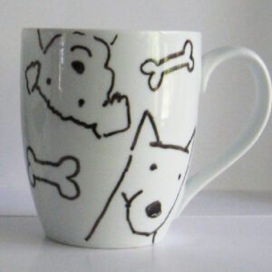 A white mug with black dogs and bone designs on it.