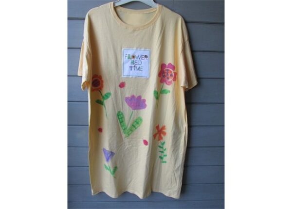 A yellow t-shirt with flowers painted on it.