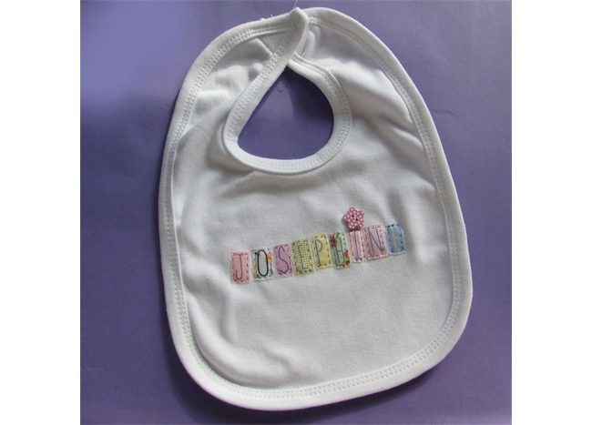 A Personalized Baby Bib with the word 'birthday' embroidered on it.