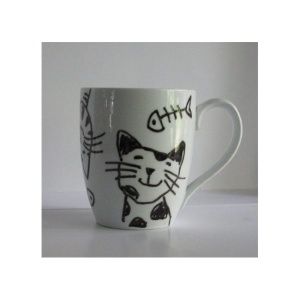 A white mug with black cat and fish designs on it.