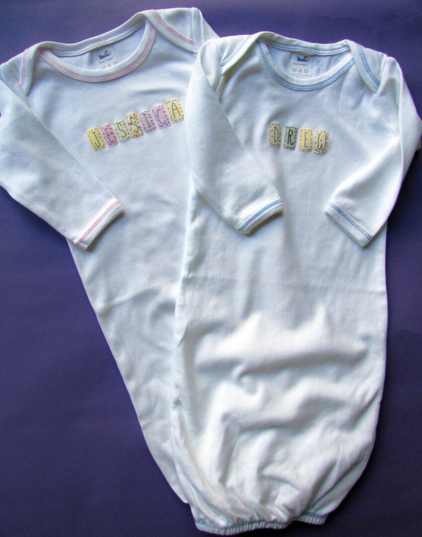 Two Baby Boy or Baby Girl Personalized Sleep Gowns with the word 'love' on them.