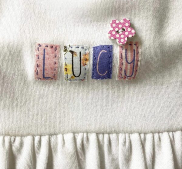 A close up of the name lucy on a blanket